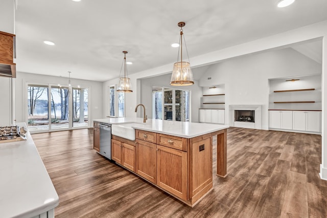 kitchen with a sink, appliances with stainless steel finishes, dark wood-type flooring, recessed lighting, and light countertops