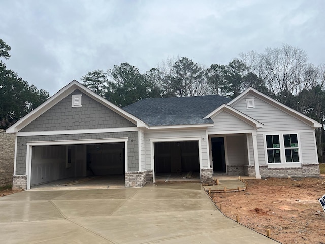 craftsman inspired home with driveway, brick siding, roof with shingles, and an attached garage