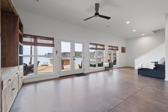 unfurnished living room with ceiling fan, recessed lighting, a water view, finished concrete flooring, and french doors