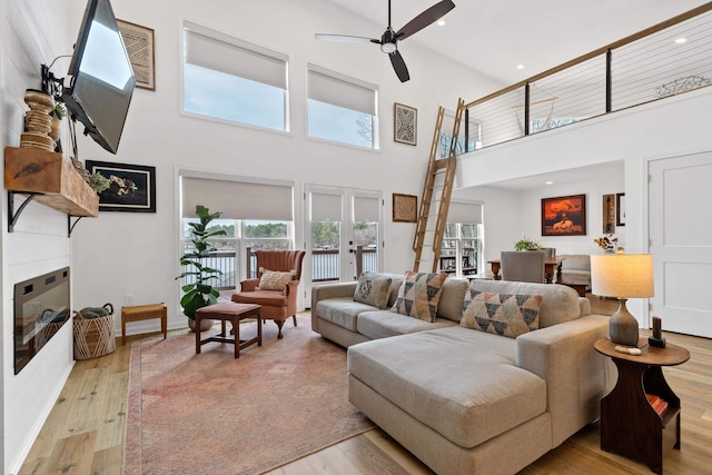 living room with french doors, recessed lighting, light wood-style floors, a fireplace, and ceiling fan