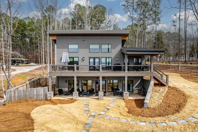 rear view of house with a patio, stairway, and fence