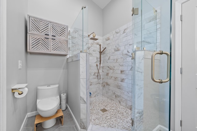 bathroom with baseboards, tile patterned floors, toilet, and a shower stall