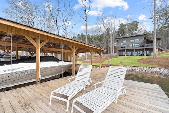 dock area with a yard, a water view, and boat lift