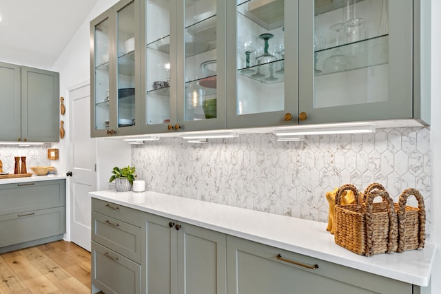 bar with light wood-style flooring and decorative backsplash