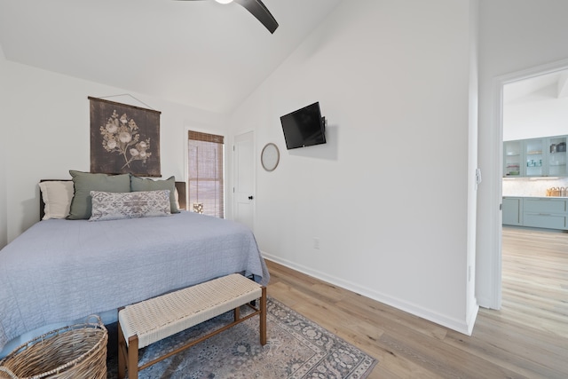 bedroom with lofted ceiling, light wood-style floors, baseboards, and a ceiling fan