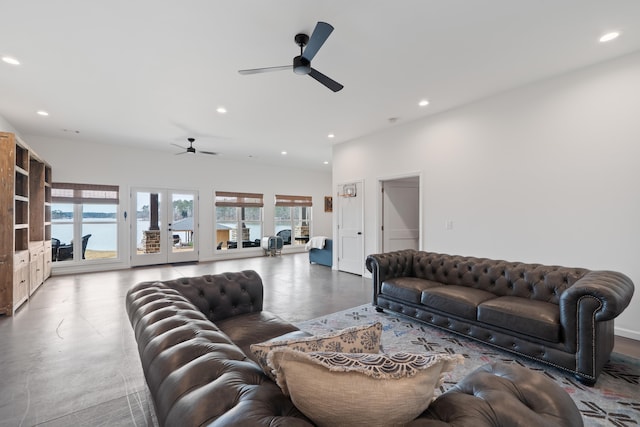 living room featuring recessed lighting, ceiling fan, concrete flooring, and a water view