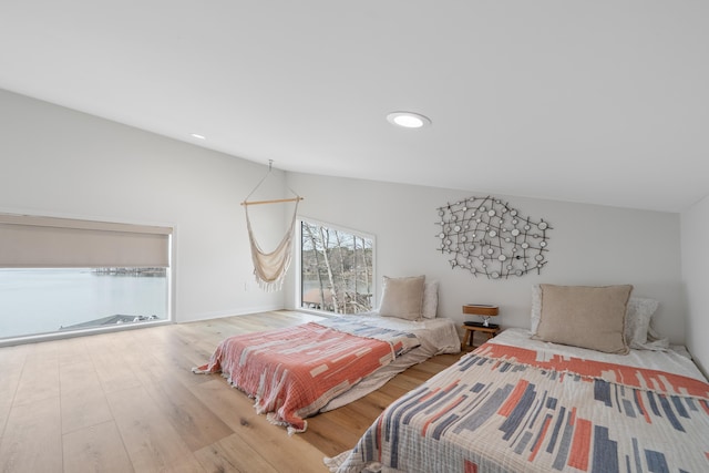 bedroom with lofted ceiling and wood finished floors