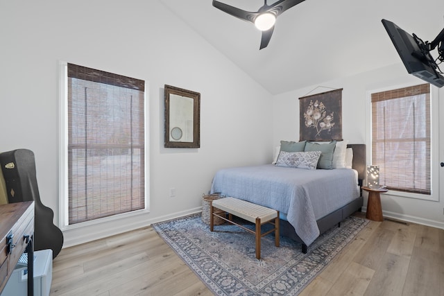 bedroom with lofted ceiling, baseboards, light wood-style flooring, and a ceiling fan