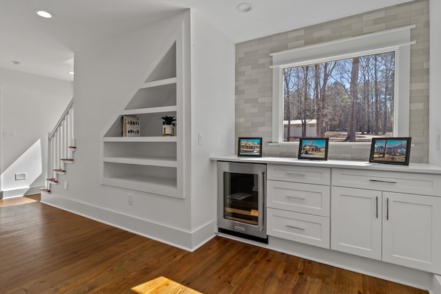 136 Hidden Lake Dr, Eatonton, GA 31024 - bar featuring wine cooler, dark wood-style flooring, built in features, stairs, and baseboards