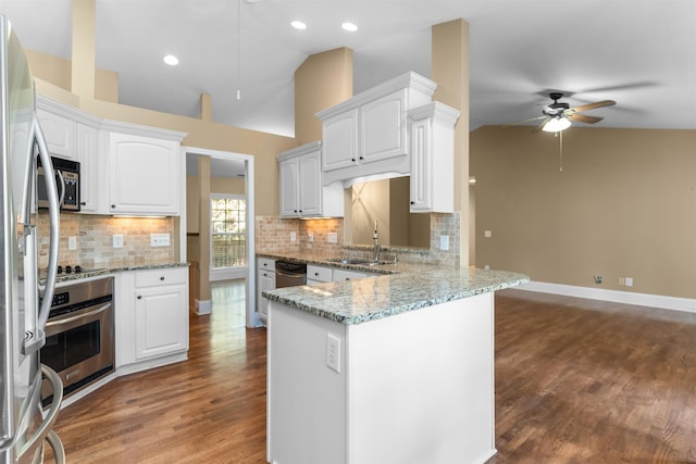 kitchen featuring lofted ceiling, white cabinetry, light stone counters, kitchen peninsula, and stainless steel appliances