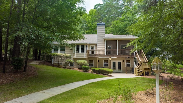 back of property featuring a yard, a sunroom, and french doors