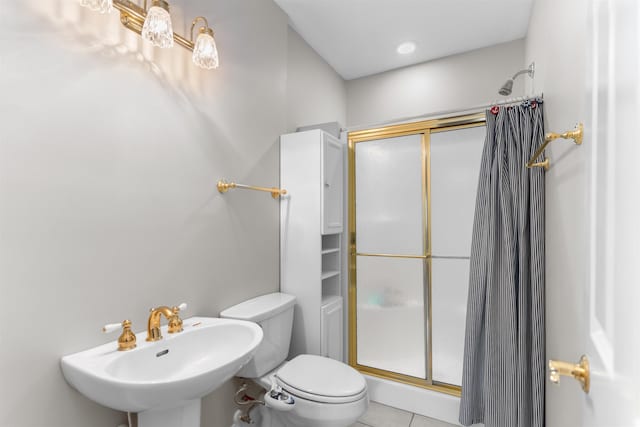 bathroom with an enclosed shower, sink, tile patterned floors, and toilet