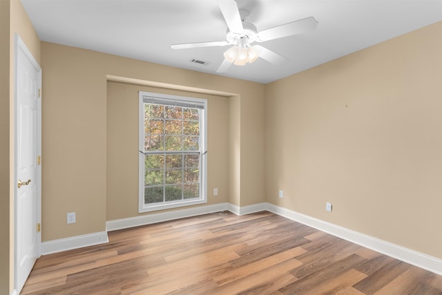 empty room with ceiling fan and light hardwood / wood-style floors