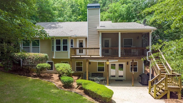 back of property with a lawn, a patio, and french doors