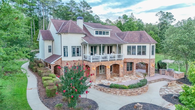 rear view of house featuring a patio area and a balcony