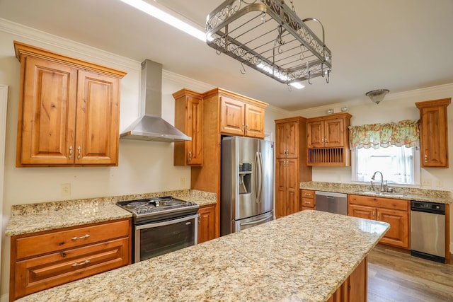 kitchen featuring stainless steel appliances, ornamental molding, sink, and wall chimney exhaust hood