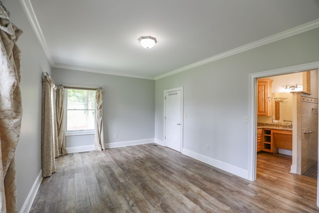 unfurnished room featuring wood-type flooring and ornamental molding