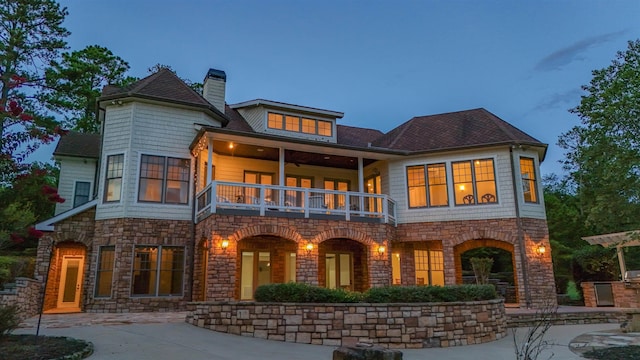 back house at dusk with a balcony