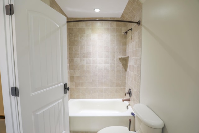 bathroom with toilet and tiled shower / bath combo