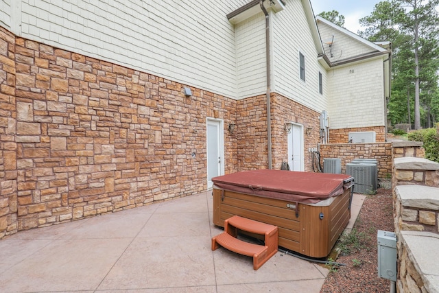 view of patio / terrace with cooling unit and a hot tub