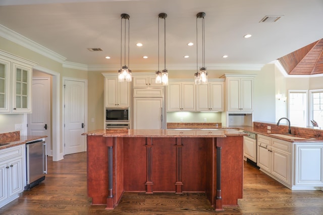 kitchen featuring built in appliances, light stone counters, pendant lighting, and a center island