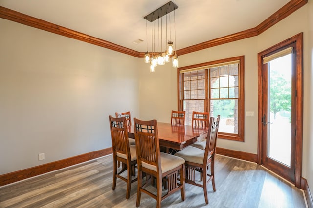 dining room with crown molding, dark wood-type flooring, and a notable chandelier