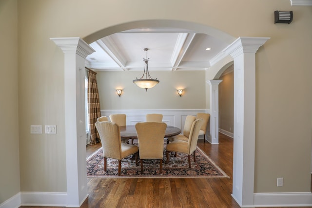 dining area featuring beam ceiling, decorative columns, dark hardwood / wood-style floors, coffered ceiling, and ornamental molding