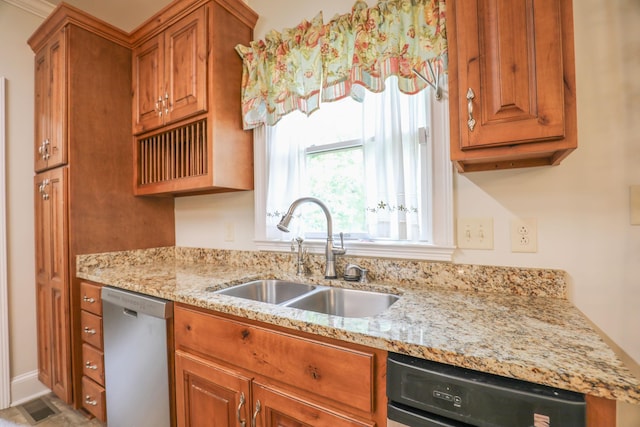 kitchen with dishwasher, sink, stainless steel dishwasher, and light stone counters