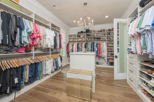 1070 Griffin Crk, Greensboro, GA 30642 - walk in closet with a chandelier and light wood-style floors