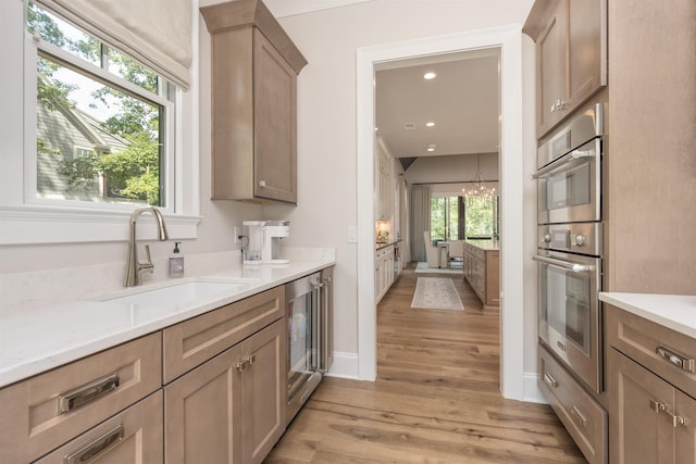 1070 Griffin Crk, Greensboro, GA 30642 - kitchen featuring stainless steel oven, wine cooler, light wood-style floors, light countertops, and a chandelier