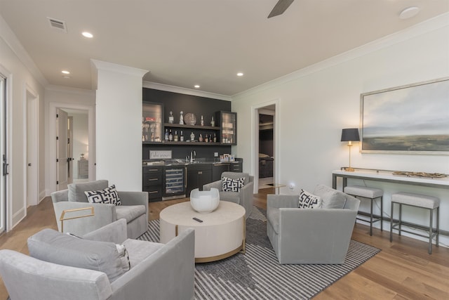 1070 Griffin Crk, Greensboro, GA 30642 - living room with bar area, wine cooler, wood finished floors, ornamental molding, and recessed lighting