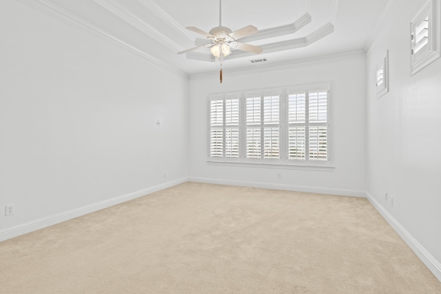 unfurnished room with crown molding, ceiling fan, a tray ceiling, and light carpet