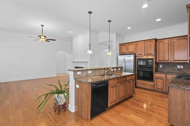 kitchen featuring sink, a center island, hanging light fixtures, decorative backsplash, and black appliances