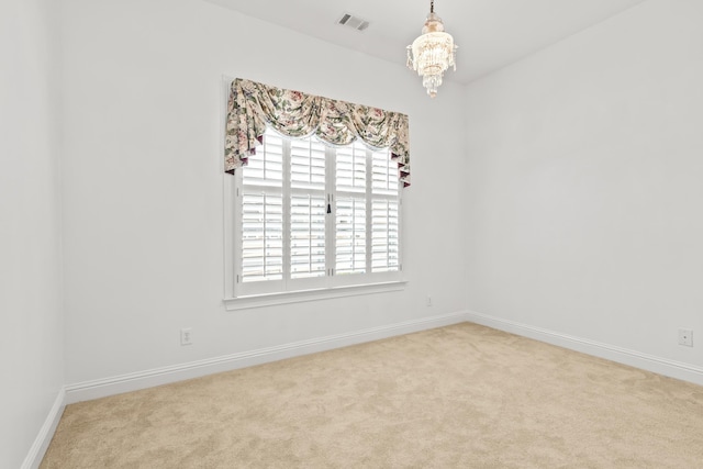 unfurnished room with light carpet and a notable chandelier