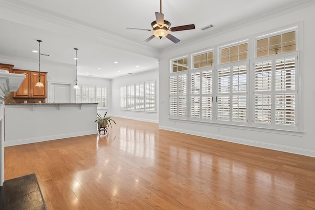 unfurnished living room with ornamental molding, ceiling fan, and light wood-type flooring