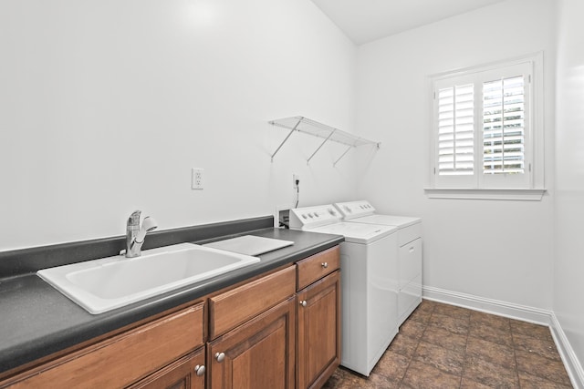 washroom with cabinets, washer and clothes dryer, and sink