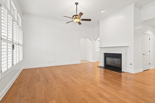 unfurnished living room with crown molding, ceiling fan, and light wood-type flooring