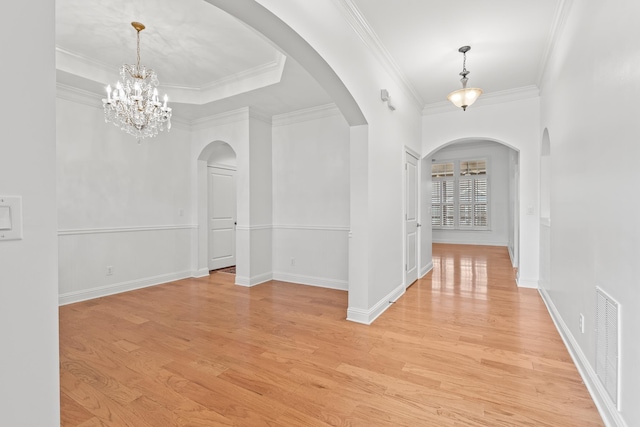 interior space featuring ornamental molding, a tray ceiling, and light hardwood / wood-style flooring