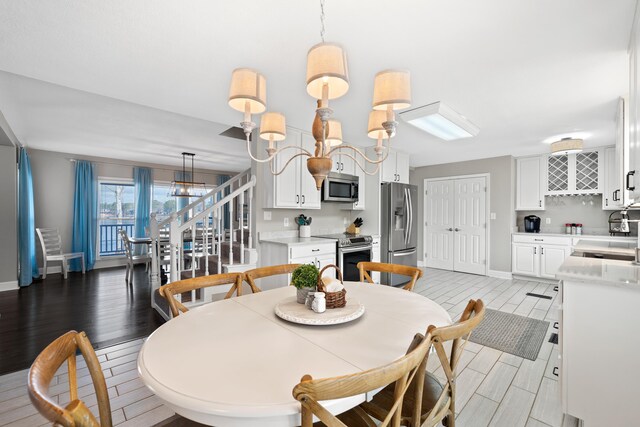 408 Sheffield Ln, Sparta, GA 31087 - dining area featuring stairs, a notable chandelier, baseboards, and wood finish floors