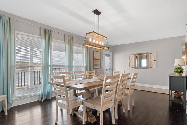408 Sheffield Ln, Sparta, GA 31087 - dining area featuring a notable chandelier, dark wood-style flooring, and baseboards