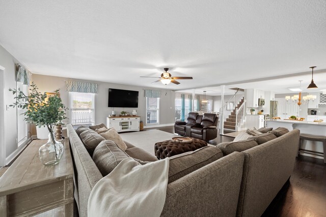 408 Sheffield Ln, Sparta, GA 31087 - living area with ceiling fan with notable chandelier, baseboards, dark wood-style floors, and stairs
