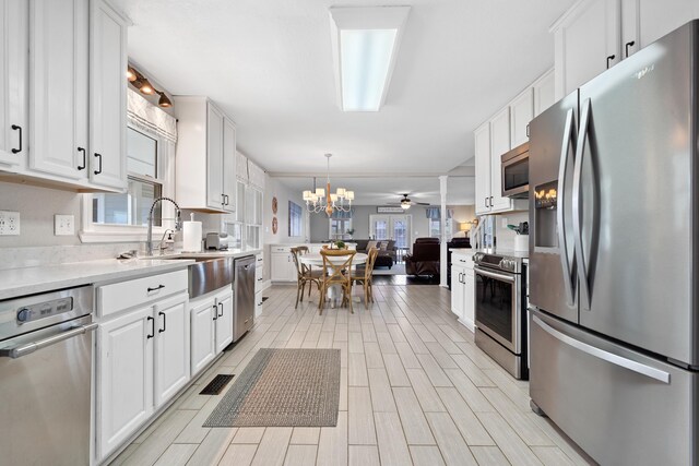 408 Sheffield Ln, Sparta, GA 31087 - kitchen featuring wood finish floors, white cabinetry, light countertops, stainless steel appliances, and open floor plan