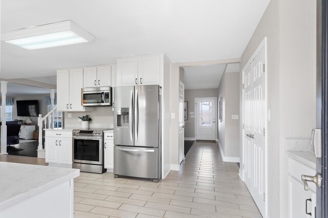 408 Sheffield Ln, Sparta, GA 31087 - kitchen with baseboards, light stone counters, white cabinetry, stainless steel appliances, and light wood finished floors