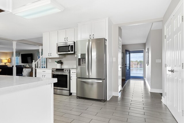 408 Sheffield Ln, Sparta, GA 31087 - kitchen featuring white cabinets, appliances with stainless steel finishes, wood finish floors, and baseboards