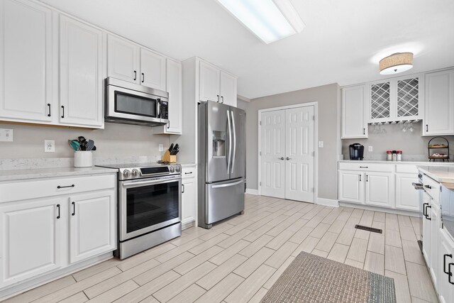 408 Sheffield Ln, Sparta, GA 31087 - kitchen with stainless steel appliances, white cabinetry, and wood tiled floor