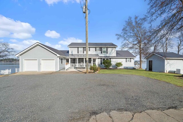 408 Sheffield Ln, Sparta, GA 31087 - view of front of house featuring a front yard, a water view, covered porch, a garage, and aphalt driveway