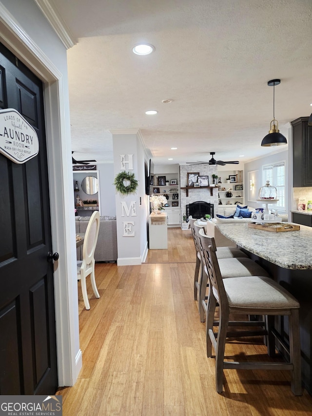 251 Pettigrew Rd, Milledgeville, GA 31061 - dining area featuring ceiling fan, light wood-type flooring, a large fireplace, and crown molding