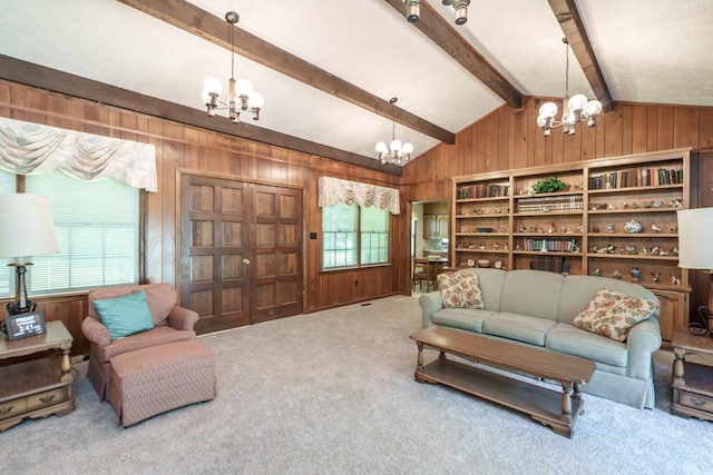 living room featuring an inviting chandelier, lofted ceiling with beams, carpet, and wood walls