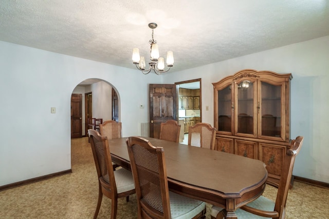 carpeted dining room with a textured ceiling and a chandelier