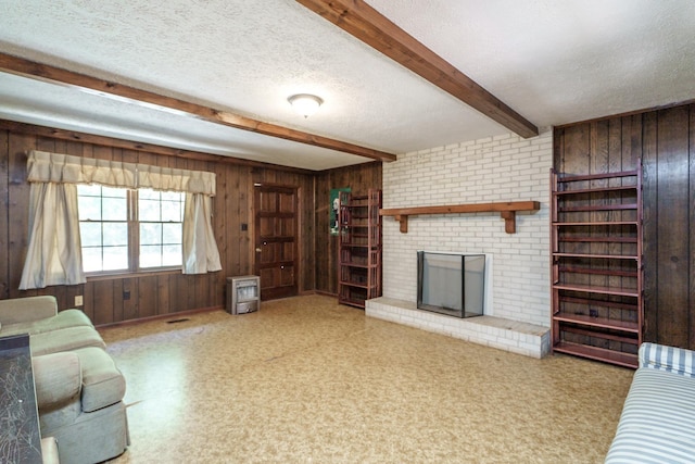 unfurnished living room with a fireplace, wooden walls, beamed ceiling, and a textured ceiling